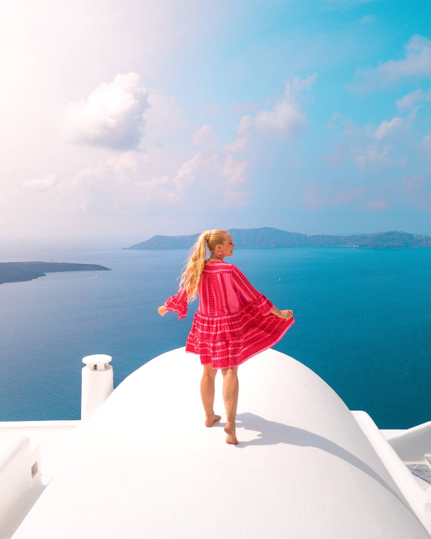 The best photo spots and most instagrammable places in Santorini: Fira rooftops overlooking the sea. Click the photo to see the rest of my list of the best instagram photo spots in Santorini!