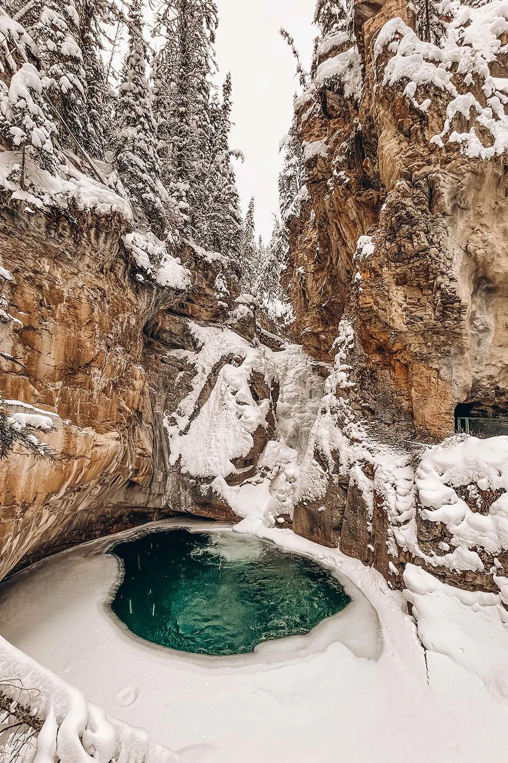 Experiencing the wonders of the Johnston Canyon ice walk is something you absolutely have to do when visiting Banff during the winter months. This guide has everything you need to know before hiking Johnston Canyon in winter. It includes tips on everything from how to prepare, what to wear, special equipment you'll need, how to find the secret cave and more! Pictured here: the Lower Falls