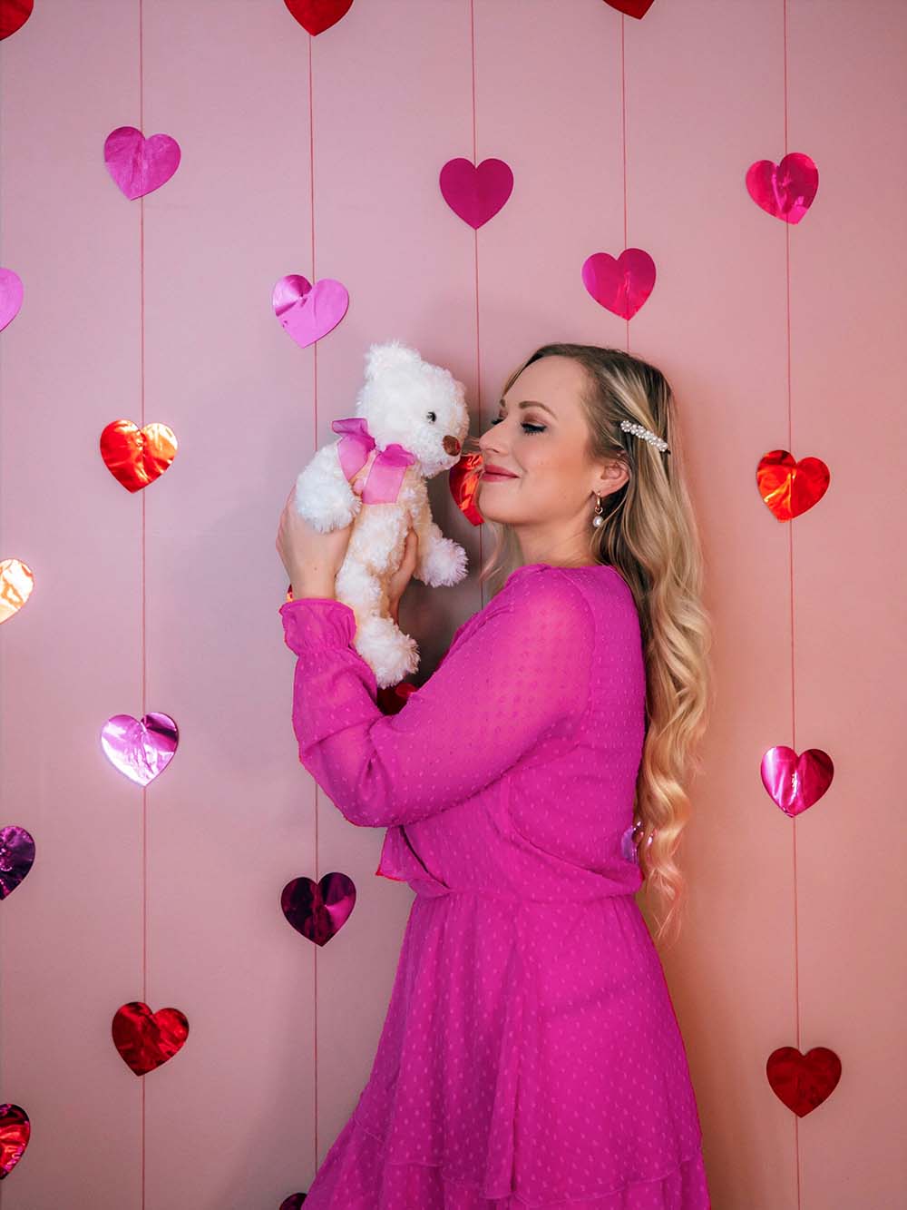 Looking for some fun & creative solo Valentine's Day photoshoot ideas to celebrate you and add a little pink and red to your instagram? This is for you! I've compiled a guide of easy Valentine's day photo ideas you can shoot at home by yourself. All of these ideas involve affordable props and are great for all photography levels. Pictured here: Add heart garlands to your wall and shoot with a teddy bear