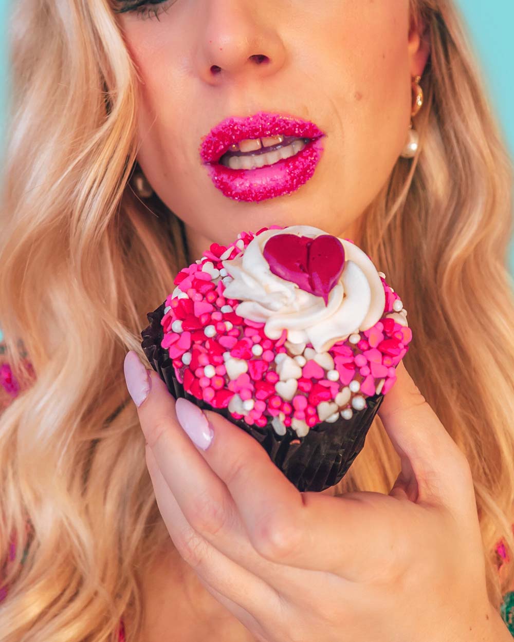 Looking for some fun & creative solo Valentine's Day photoshoot ideas to celebrate you and add a little pink and red to your instagram? This is for you! I've compiled a guide of easy Valentine's day photo ideas you can shoot at home by yourself. All of these ideas involve affordable props and are great for all photography levels. Pictured here: Cover your lips with sprinkles and shoot up close with a cupcake