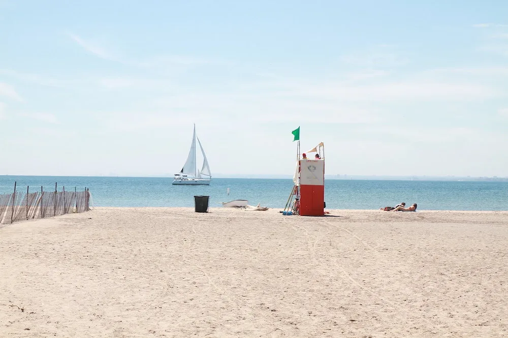 Looking for a great beach to spend a hot summer day laying in the sun on? This guide to the best beaches in Toronto is for you! Whether you're looking for a relaxing and quiet beach hang, the perfect beach for a family picnic, or want to enjoy the beach life in a more lively environment, there is Toronto beach for you. Pictured here: Hanlan's Point Beach