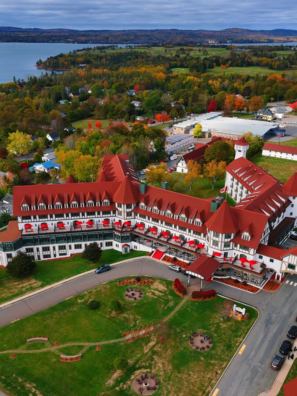 Aerial drone view of the Algonquin Resort in St. Andrews by-the-Sea, New Brunswick, surrounded by fall foliage and overlooking the Bay of Fundy.