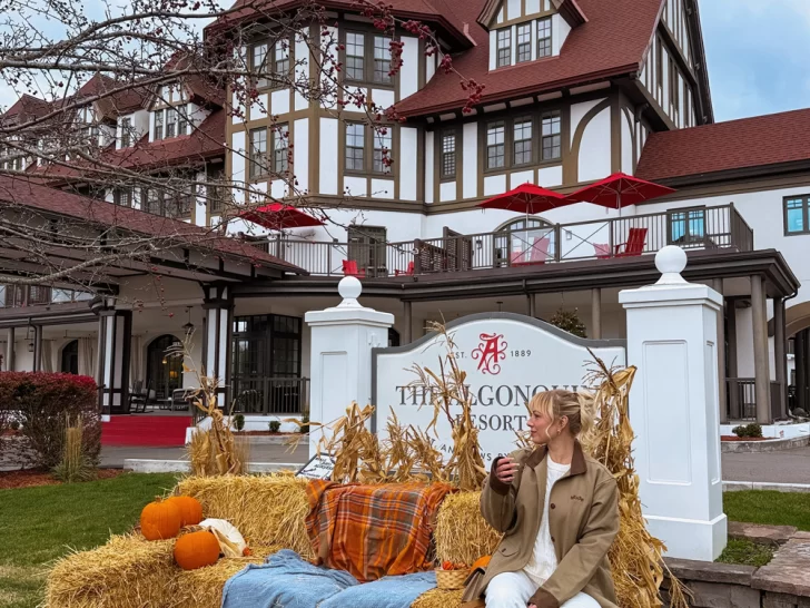 Woman enjoying a glass of wine surrounded by pumpkins and fall d&eacute;cor in front of the historic Algonquin Resort in St. Andrews by-the-Sea, New Brunswick