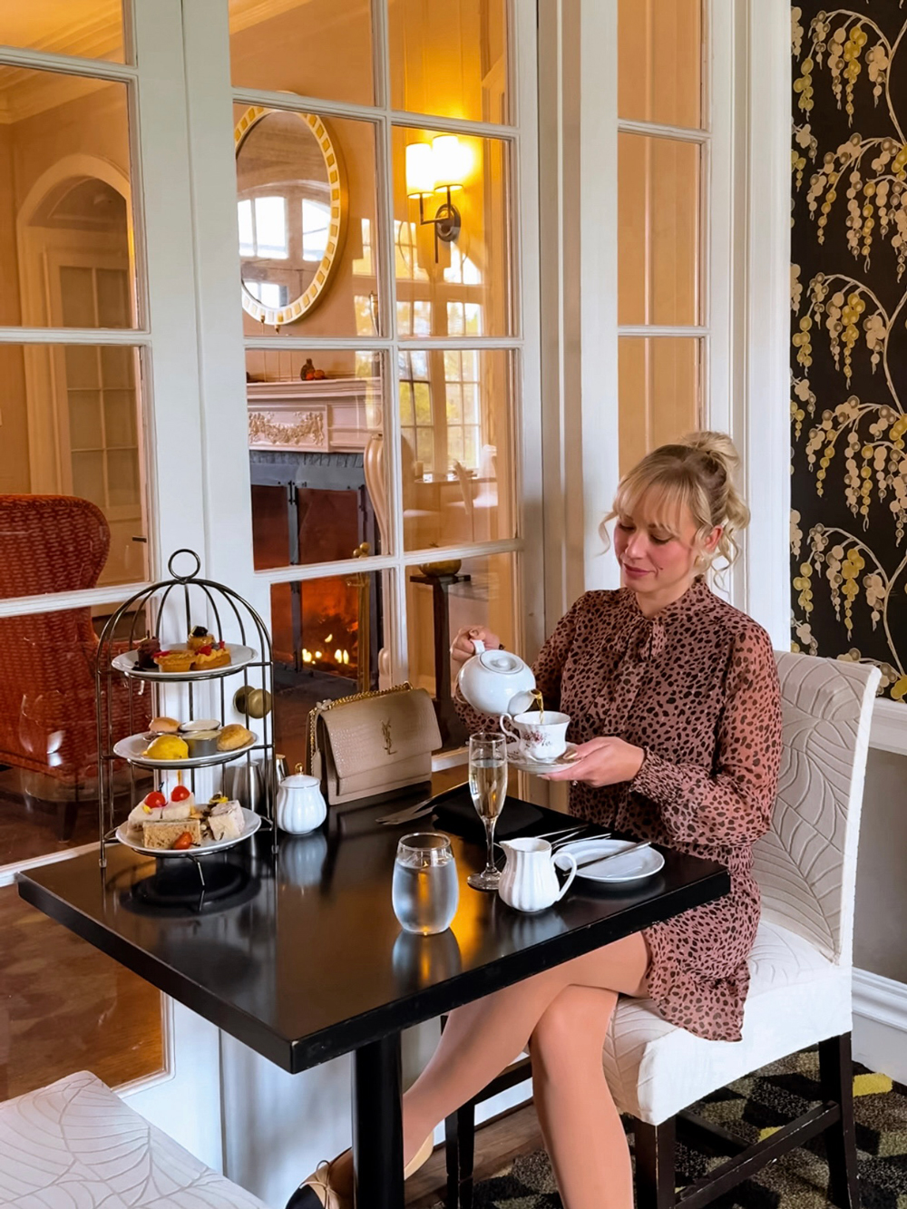 Afternoon tea at the Algonquin Resort with tiered trays of pastries, scones, and tea cups in a bright lounge overlooking the property.
