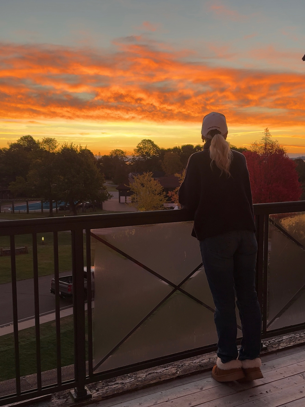 Woman admires a beautiful sunrise from her balcony at the Algonquin Resort in St. Andrews, New Brunswick.