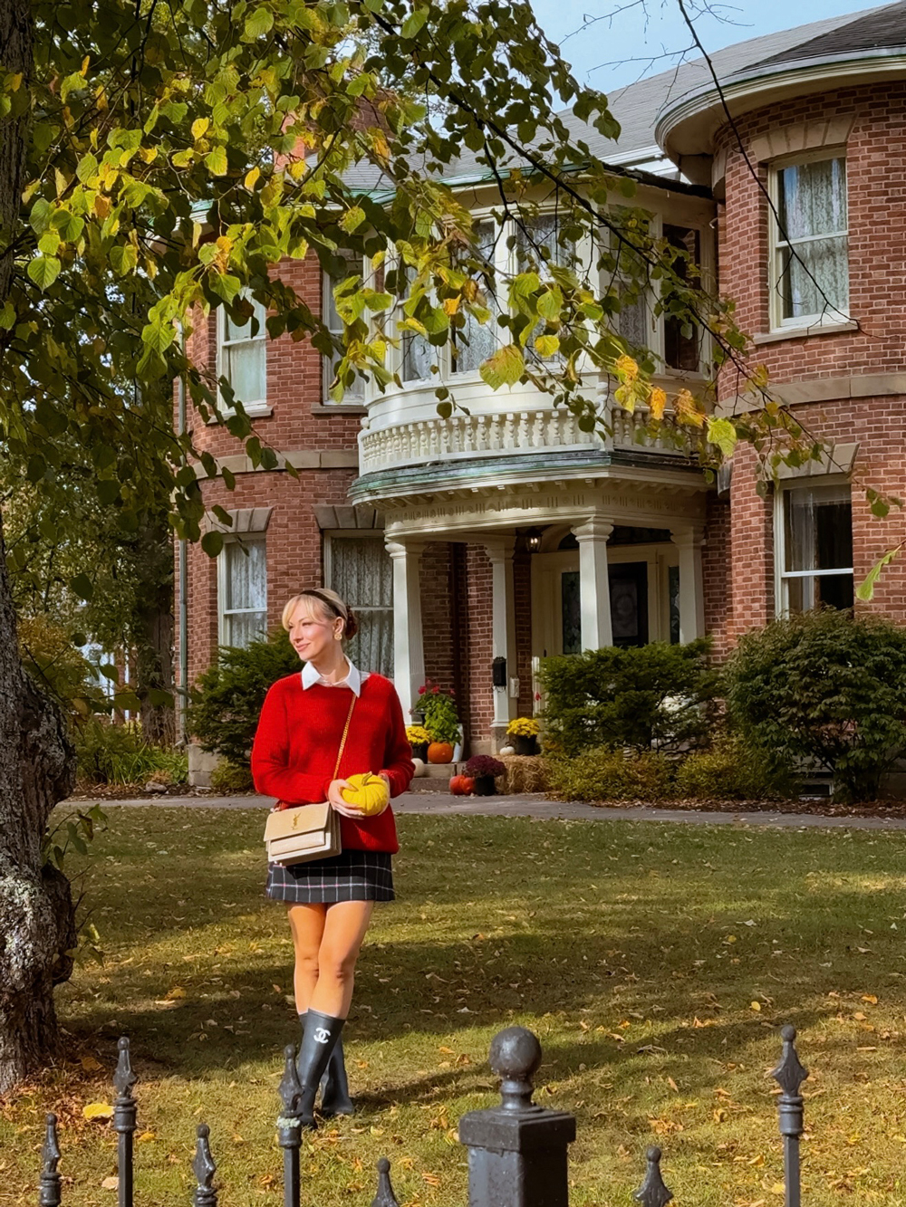 Fall at Fairholm Boutique Inns in Charlottetown, PEI &mdash; woman standing on the steps surrounded by pumpkins and festive d&eacute;cor.