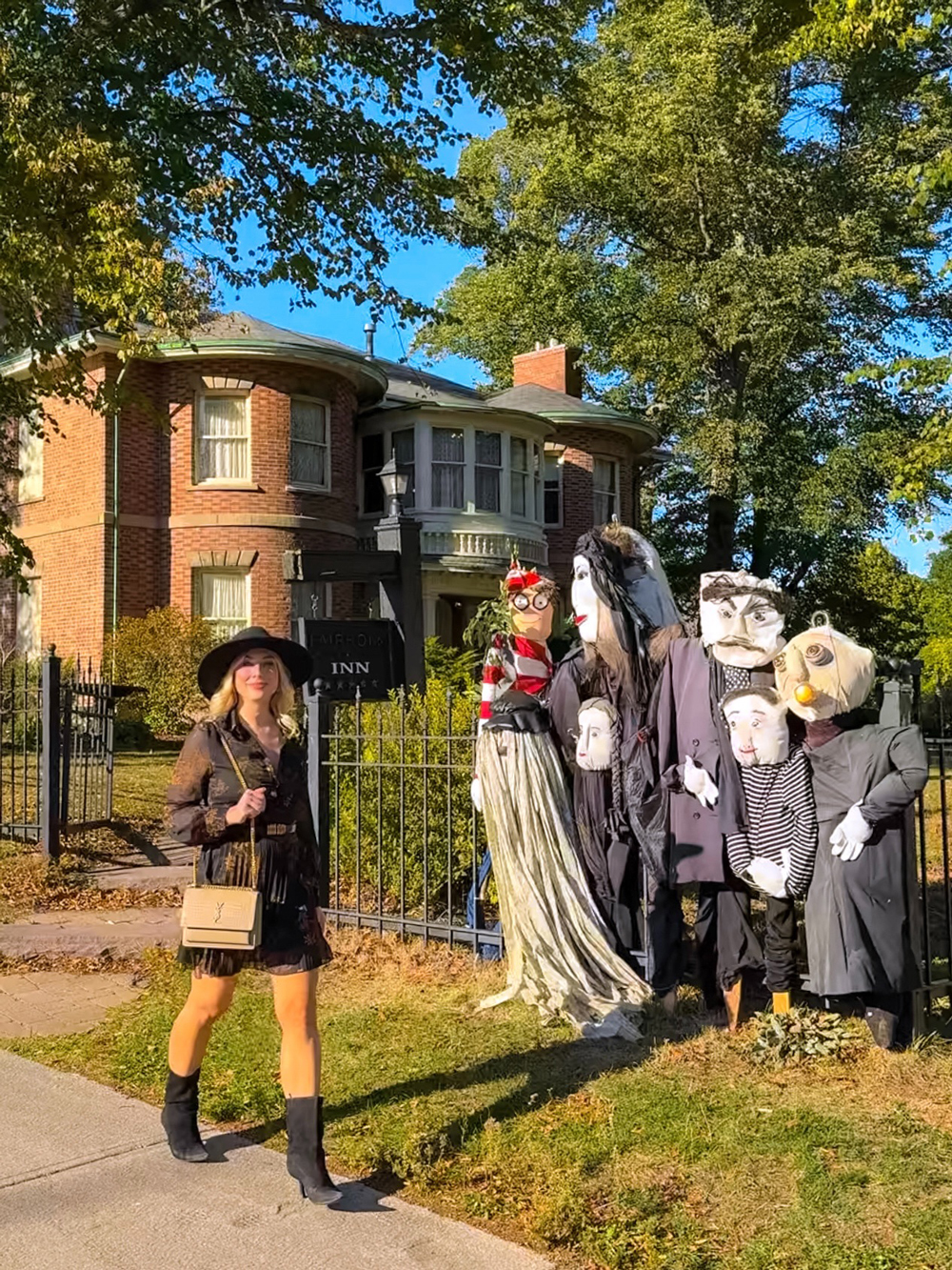 Visiting the Charlottetown Scarecrow Festival &mdash; woman walking past creative scarecrow displays in front of the Fairholm Boutique Inns.