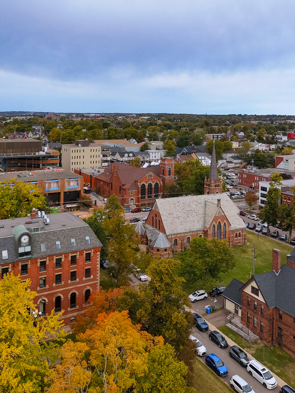 Drone view of Charlottetown, Prince Edward Island in autumn &mdash; historic red-brick buildings surrounded by colorful fall trees.