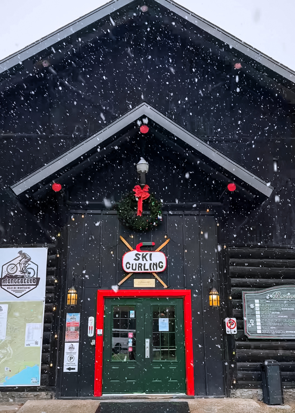 Entrance to the curling and ski building in Montebello decorated with a Christmas wreath during a snowfall.