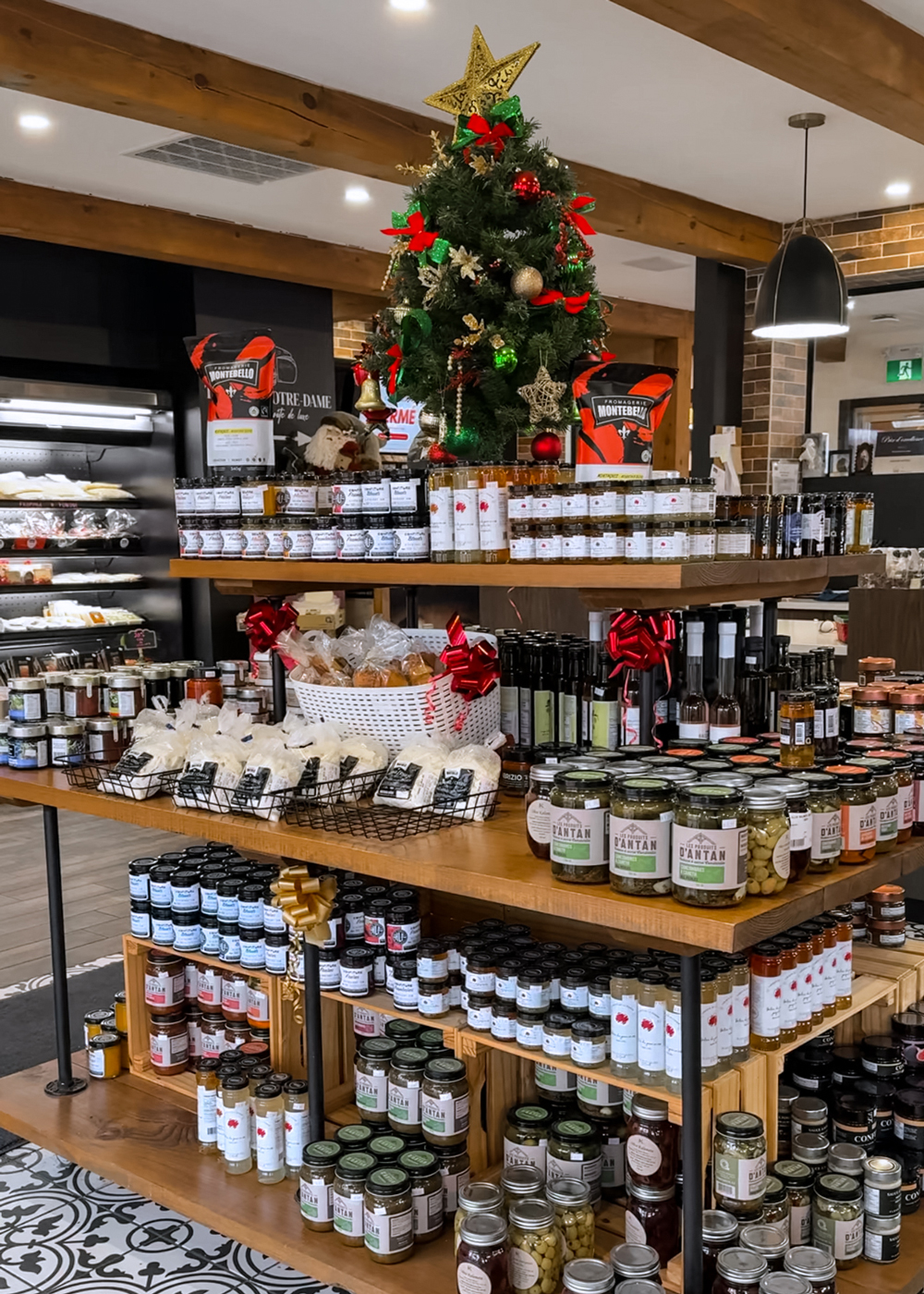 Display of local gourmet products, preserves, and holiday treats at a Montebello specialty shop decorated with a Christmas tree.
