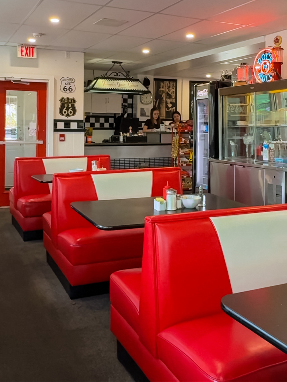 Interior of Hoagie's Retro Diner in North Bay, with red booths, Route 66 signs, and a counter area with staff.