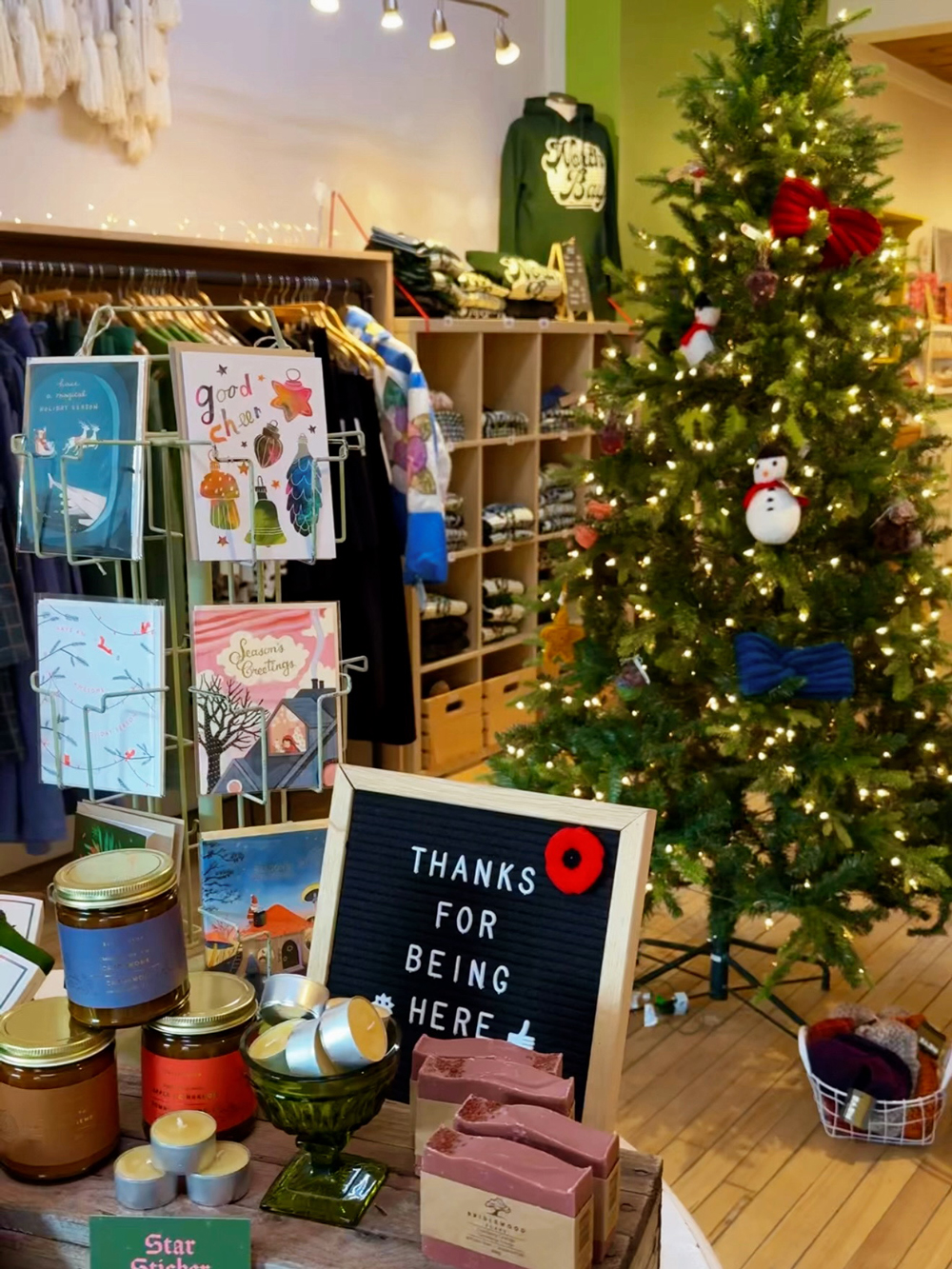 Holiday display inside a North Bay boutique with a lit Christmas tree, greeting cards, and gift items.