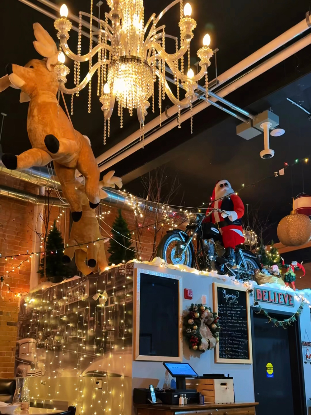 Festive display inside The Block Public House in North Bay, with a chandelier, a stuffed reindeer, and Santa riding a motorcycle above the bar.