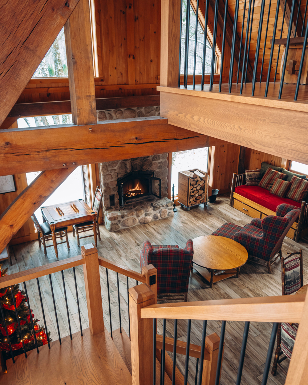 View from the loft of a Kenauk Nature chalet overlooking the cozy living room and stone fireplace.